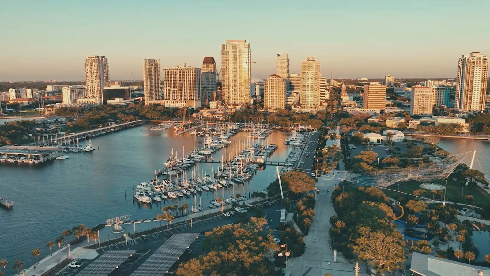 An aerial view of the downtown St. Petersburg waterfront and marina at golden hour.